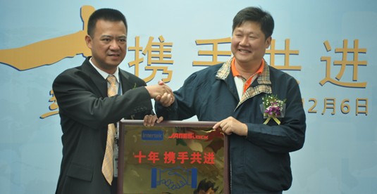共同紧握纪念牌，握手走向更深的合作